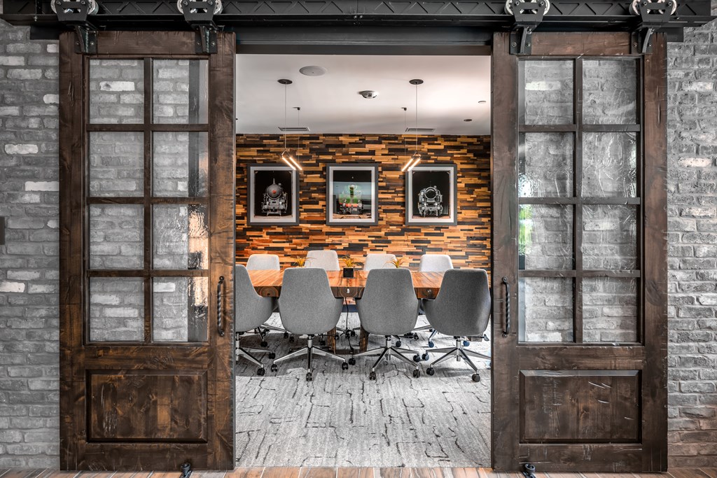 A room with a brick wall and a table with chairs in front of it.