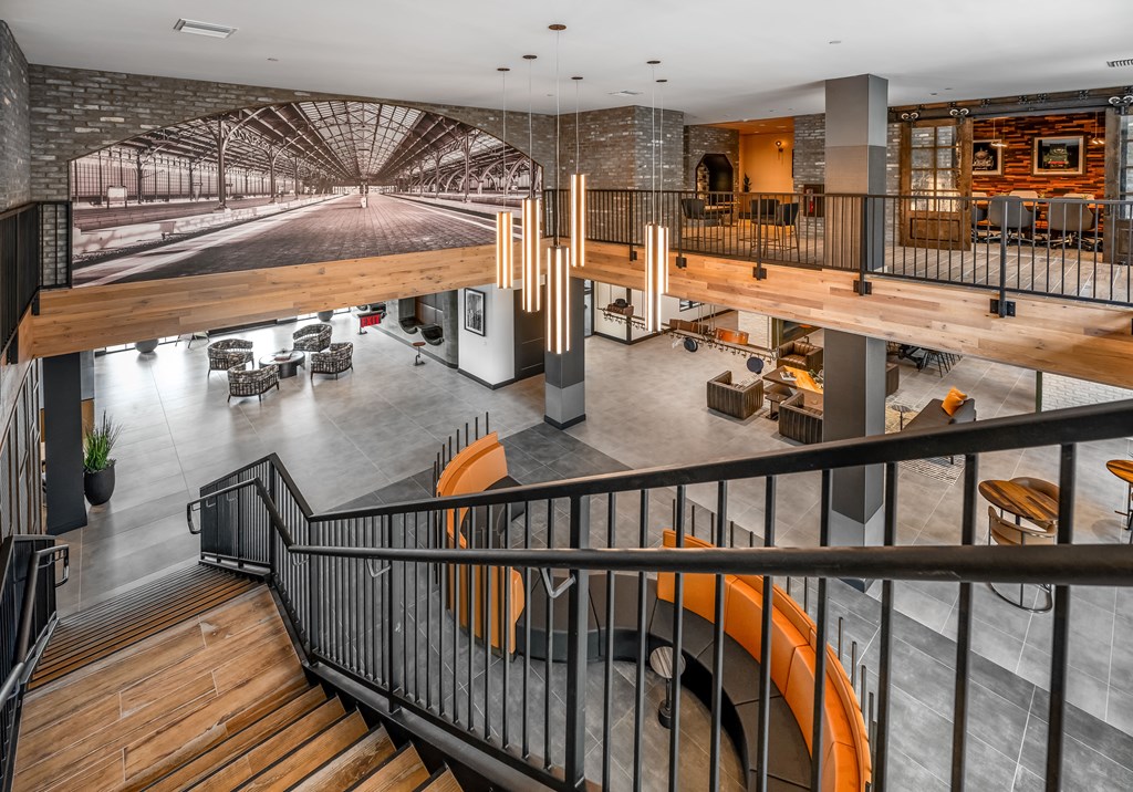 A modern interior with a staircase and a large mural on the wall.