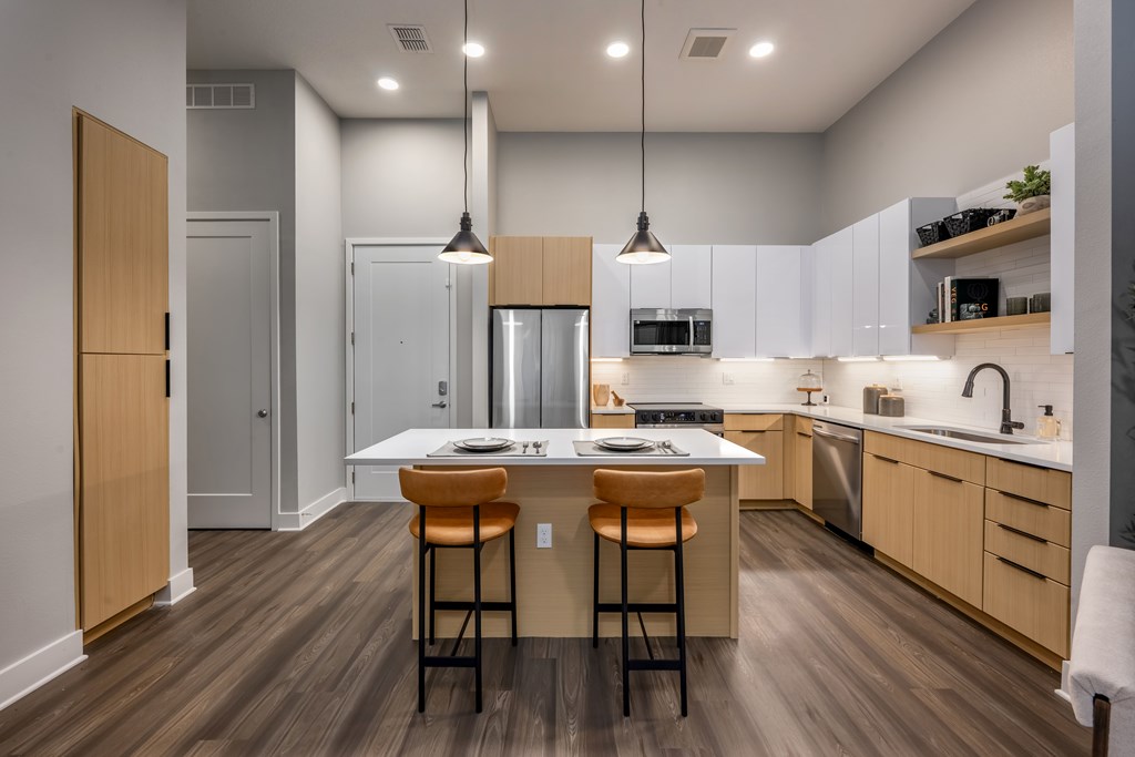 A modern kitchen with a center island and bar stools.