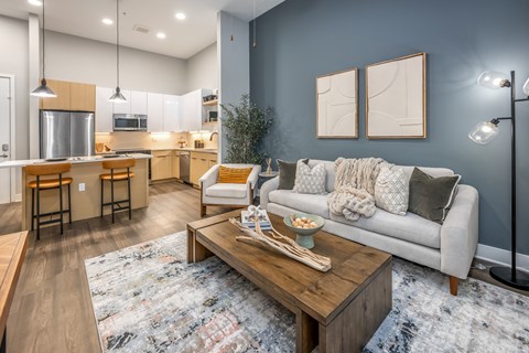 A modern living room with a grey couch and a wooden coffee table.