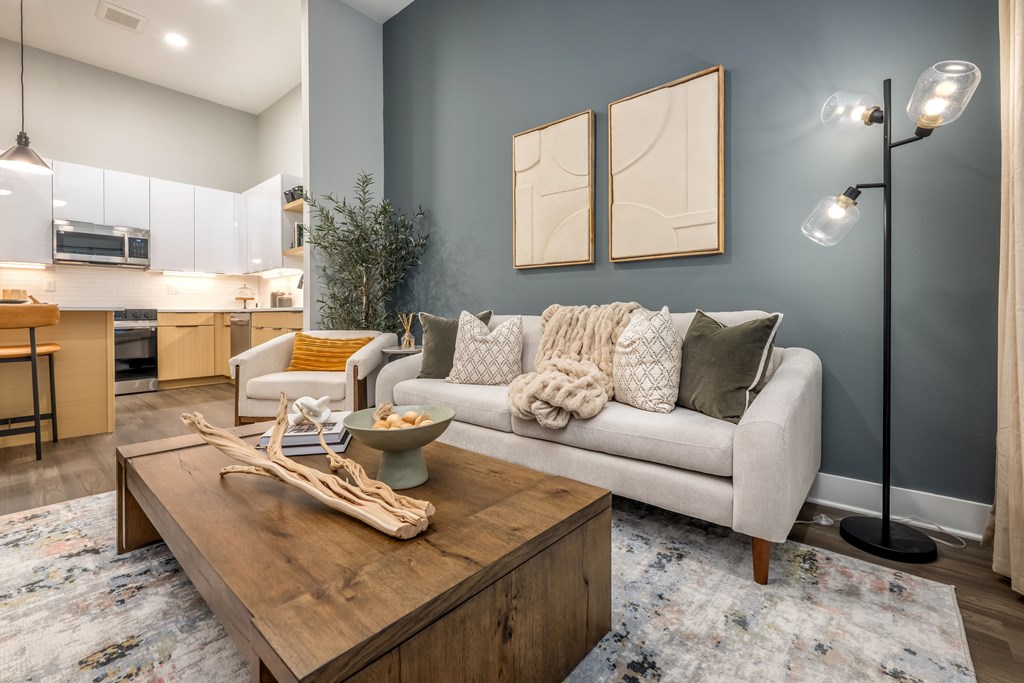 A modern living room with a white couch and a wooden coffee table.