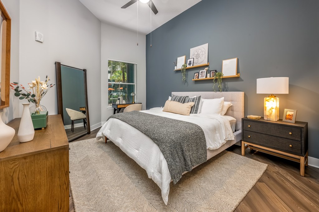 A bedroom with a bed, nightstand, and a chair.