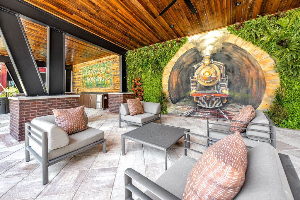 A train mural on a wall in a room with a fireplace and seating area.