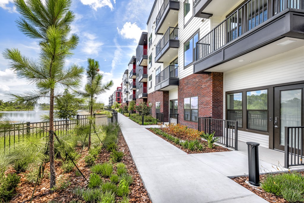 A modern apartment complex with a walkway and landscaping.