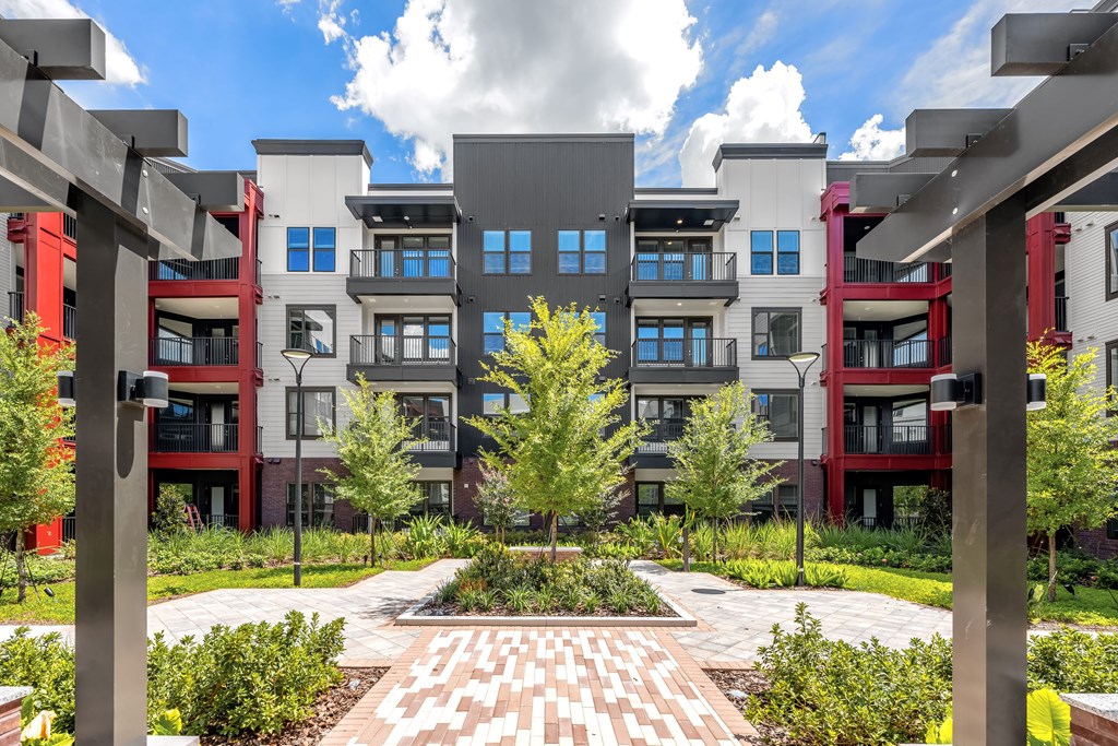 A modern building complex with a courtyard in the foreground.