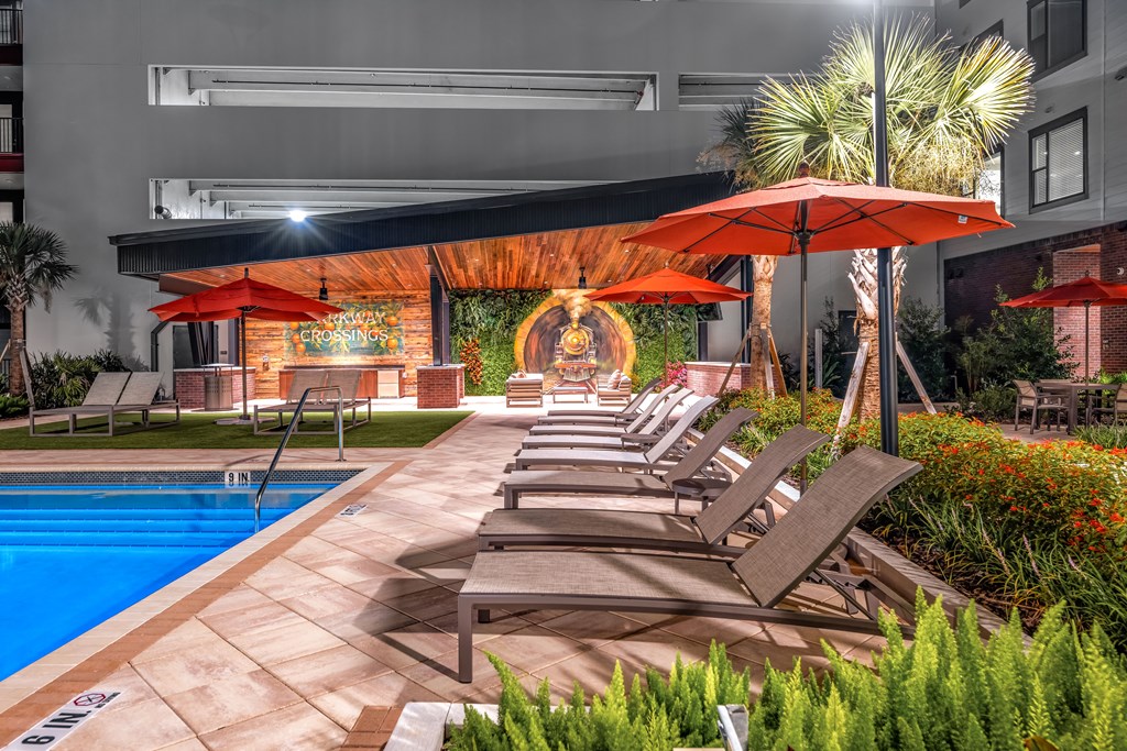A pool area with lounge chairs and umbrellas.
