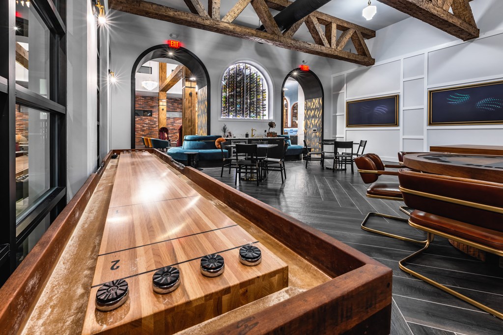 a bar with a shuffleboard table in the center of a room with a table