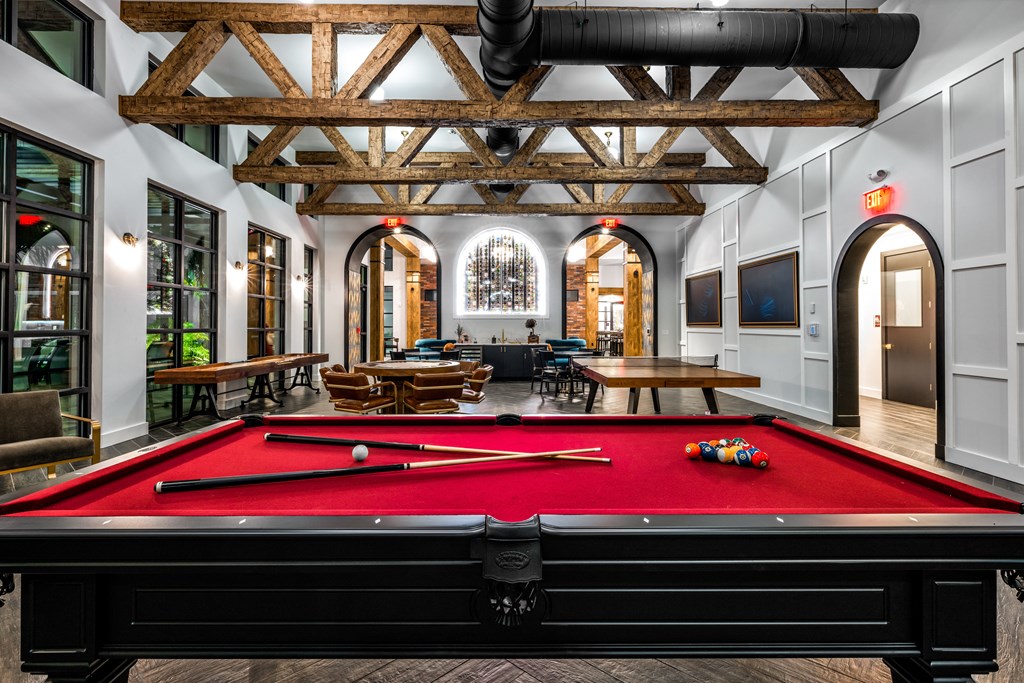a pool table in the lobby of a building with a lounge area and a large at The Alibi at Lake Lilly, Ocoee, FL, 34761