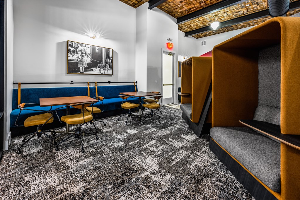 a lounge area with tables and chairs and a television