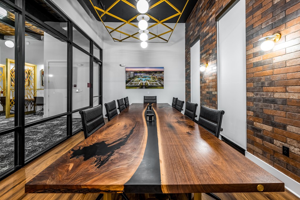 a conference room with a long wooden conference table and brick walls
