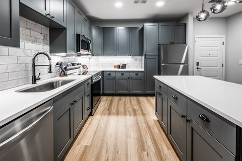 a kitchen with stainless steel appliances and gray cabinets