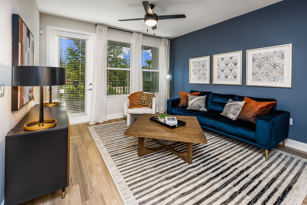 a living room with a blue couch and a wooden coffee table at The Alibi at Lake Lilly, Ocoee, FL