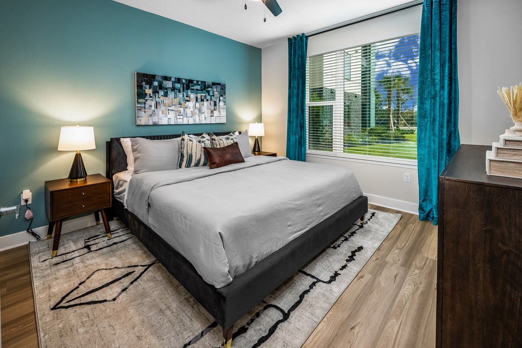a bedroom with a bed and a large window with blue curtains at The Alibi at Lake Lilly, Ocoee, FL