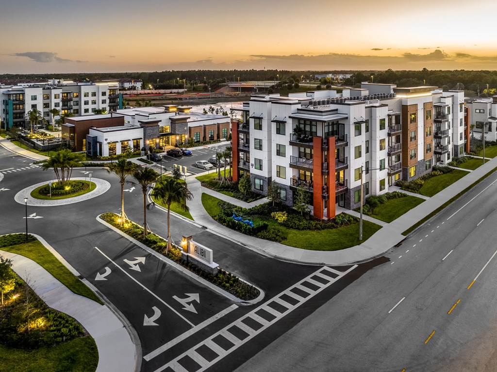 an aerial view of an empty parking lot with apartment buildings