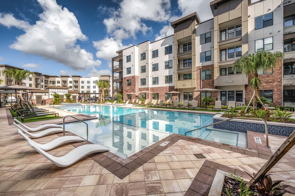 a swimming pool at an apartment building with a pool and lounge chairs a swimming pool at an apartment building with a pool and lounge chairs at The Haven at Lake Britt Apartments, Winter Garden, 34787