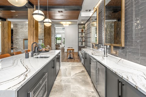 a large kitchen with two sinks and marble counter tops