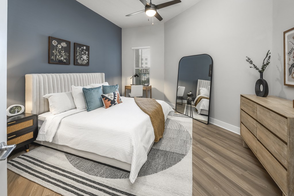a bedroom with a large bed and a mirror a bedroom with a large bed and a mirror at The Haven at Lake Britt Apartments, Winter Garden
