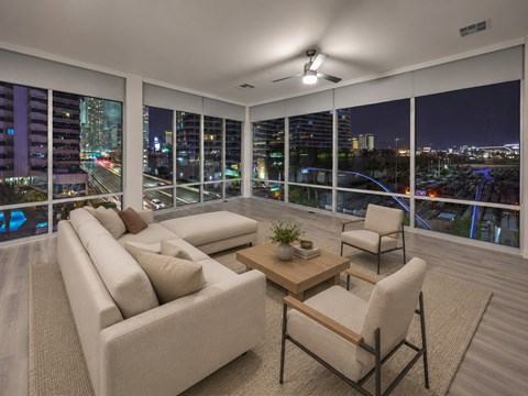 A living room with a couch, chair, and a table with a plant on it.