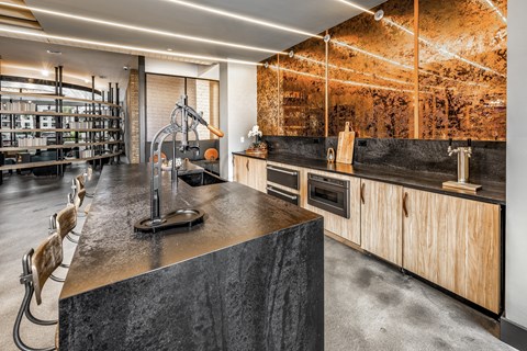 a kitchen with concrete countertops and wooden cabinets and a wine cellar