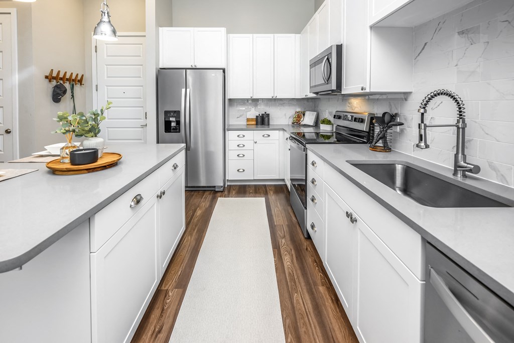 a large kitchen with white cabinets and stainless steel appliances at The Overlook, Winter Garden, FL, 34787