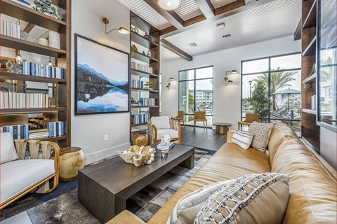 A living room with a large couch, a coffee table, and a bookshelf.
