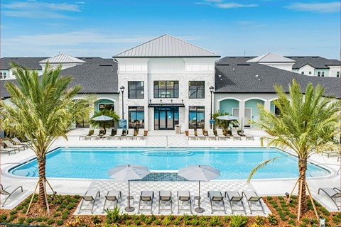 A large white building with a pool in front.