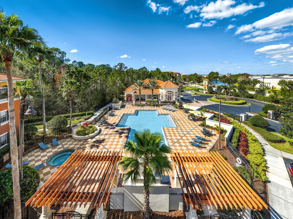 an aerial view of the resort style pool with lounge chairs and palm trees