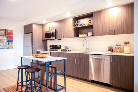 a kitchen with a small table and two stools