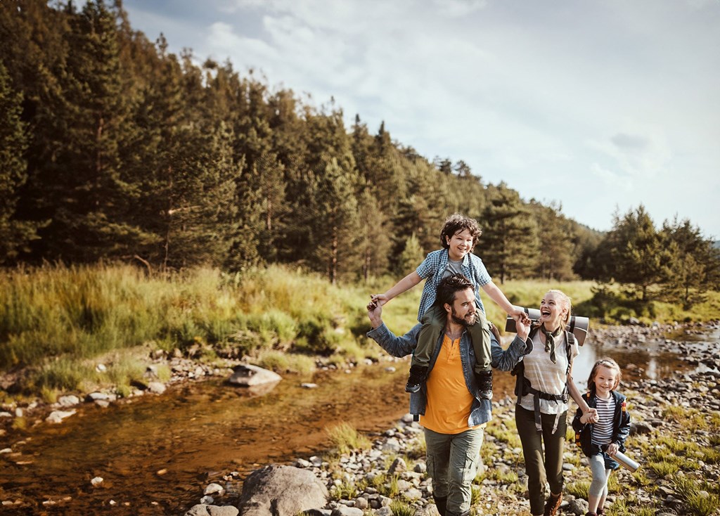 a family walking down a trail with a child on their shoulders
