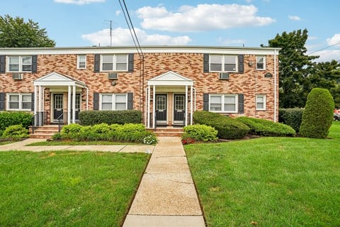 A brick house with a green lawn in front.