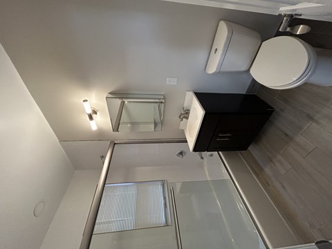 A modern bathroom with a glass shower stall and a toilet.