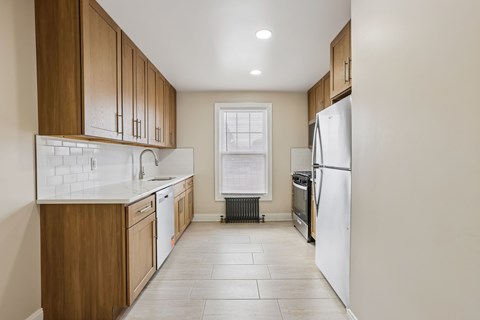 A kitchen with wooden cabinets and a white refrigerator.