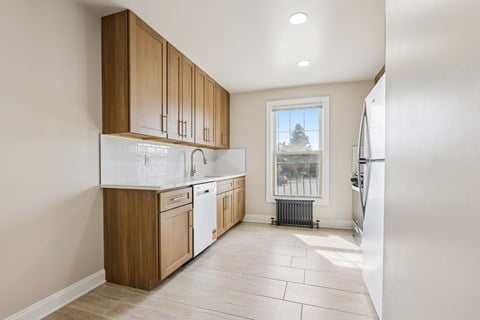 A kitchen with wooden cabinets and a white refrigerator.