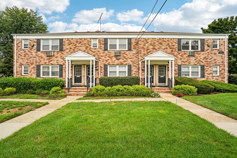 A brick house with a green lawn in front.