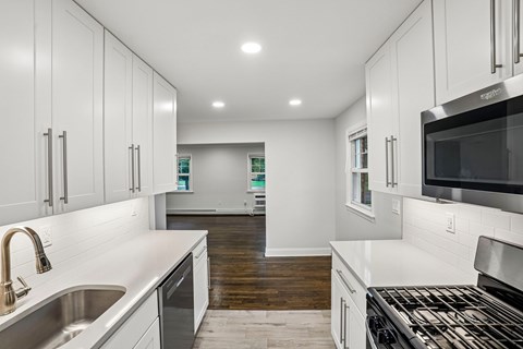 A modern kitchen with white cabinets and stainless steel appliances.