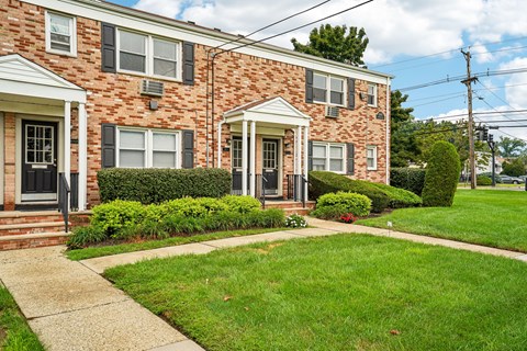 A brick house with a green lawn in front.