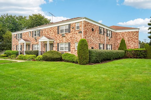 A brick house with a green lawn in front.
