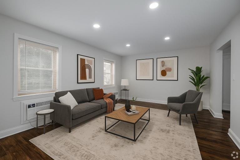 A living room with a grey couch, a coffee table, and a lamp.