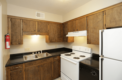 A kitchen with wooden cabinets and white appliances.