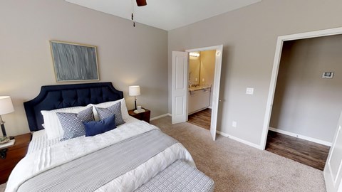 A bedroom with a large bed and a ceiling fan.