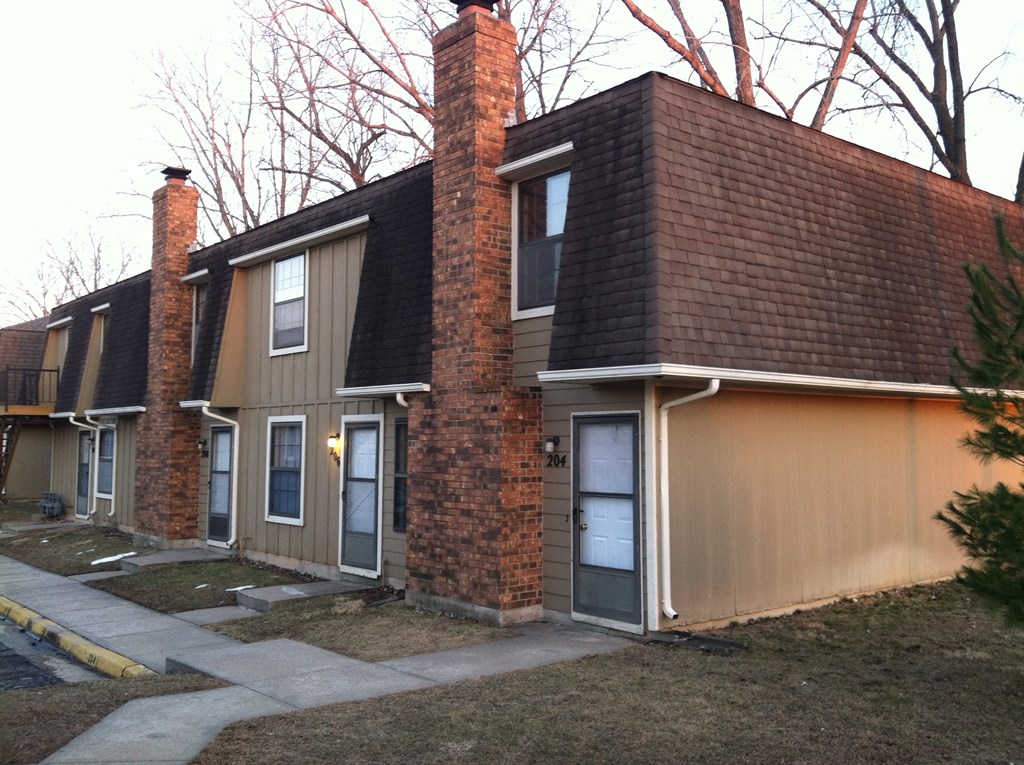 a row of houses with a sidewalk in front of them