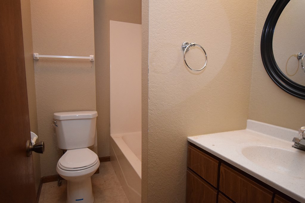 a bathroom with a toilet and a tub and a sink