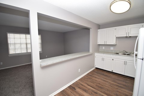 A kitchen with white cabinets and a refrigerator.
