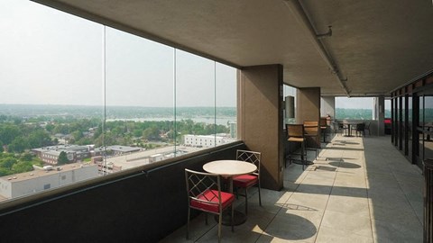 Enclosed exterior walkway with seating and Sloan's Lake in the distance at Denver Metro Village Apartments, Denver, CO, 80204