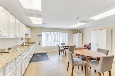 A kitchen with a table and chairs in the middle of the room.