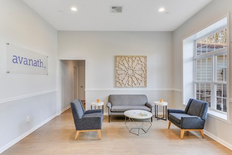 A living room with a couch, chairs, and a table with a sign that says "avanath.".