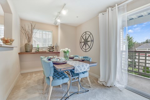 A dining room with a table set for four.