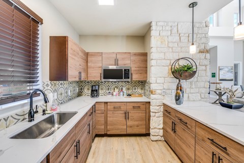A kitchen with wooden cabinets and a stone backsplash.