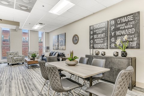 A conference room with a long table and chairs, a couch, and a wall with a list of names. at Academy at Drexel Apartments, Chicago, IL, 60637