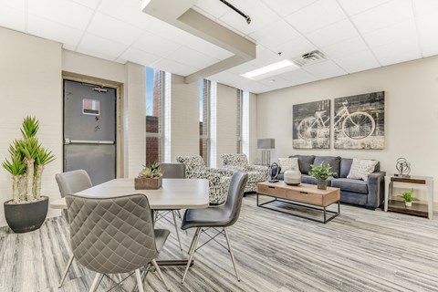 A modern living room with a grey dining table and grey chairs.
